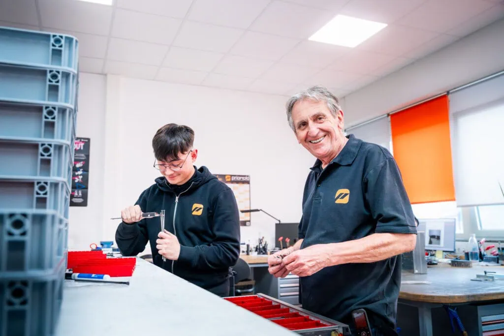 Ausbildung und Karriere bei priomold: Auszubildender und erfahrener Mitarbeiter arbeiten gemeinsam in der Werkstatt.