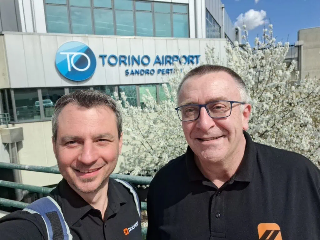 Zwei priomold Mitarbeiter am Torino Airport als Teil von priomold on Tour und internationaler Kunden- und Messeaktivität.