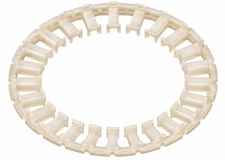 Transparenter, beige-milchiger Kunststoffring aus Spritzguss mit radial angeordneten Stegen auf weißem Hintergrund.