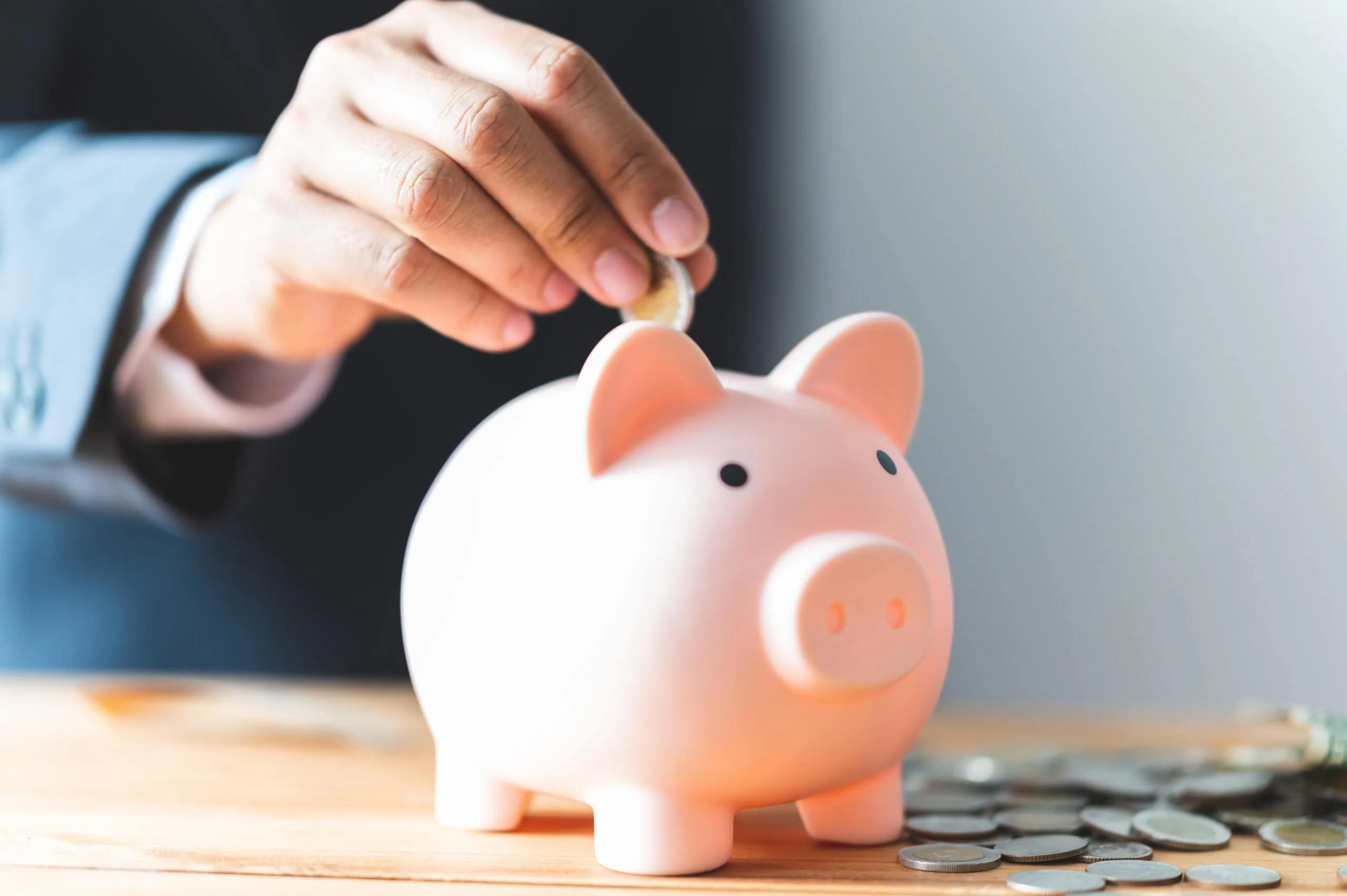 Sparschwein mit Münzen als Symbol für die betriebliche Altersvorsorge bei priomold
