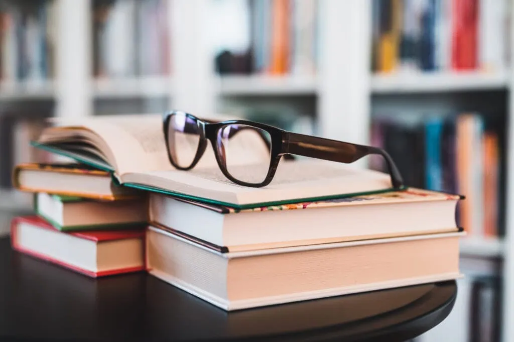 Bücher und Brille als Symbol für die kostenlose Bücherflat bei priomold
