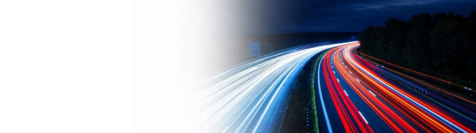 Autobahn bei Nacht mit Lichtspuren als Symbol für Transport und Mobilität