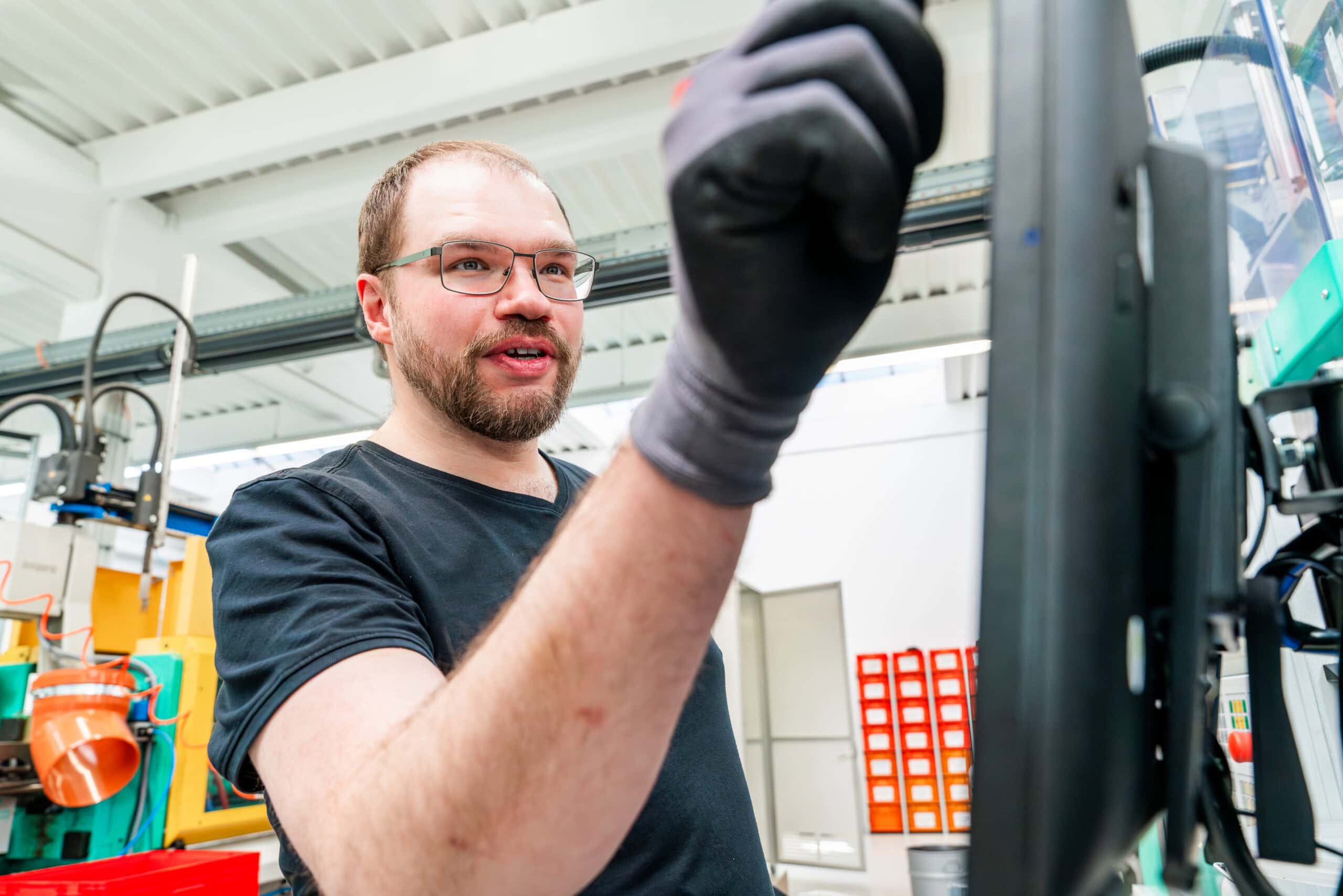 Mitarbeiter bedient eine moderne Spritzgussmaschine in der Kunststofffertigung bei priomold.