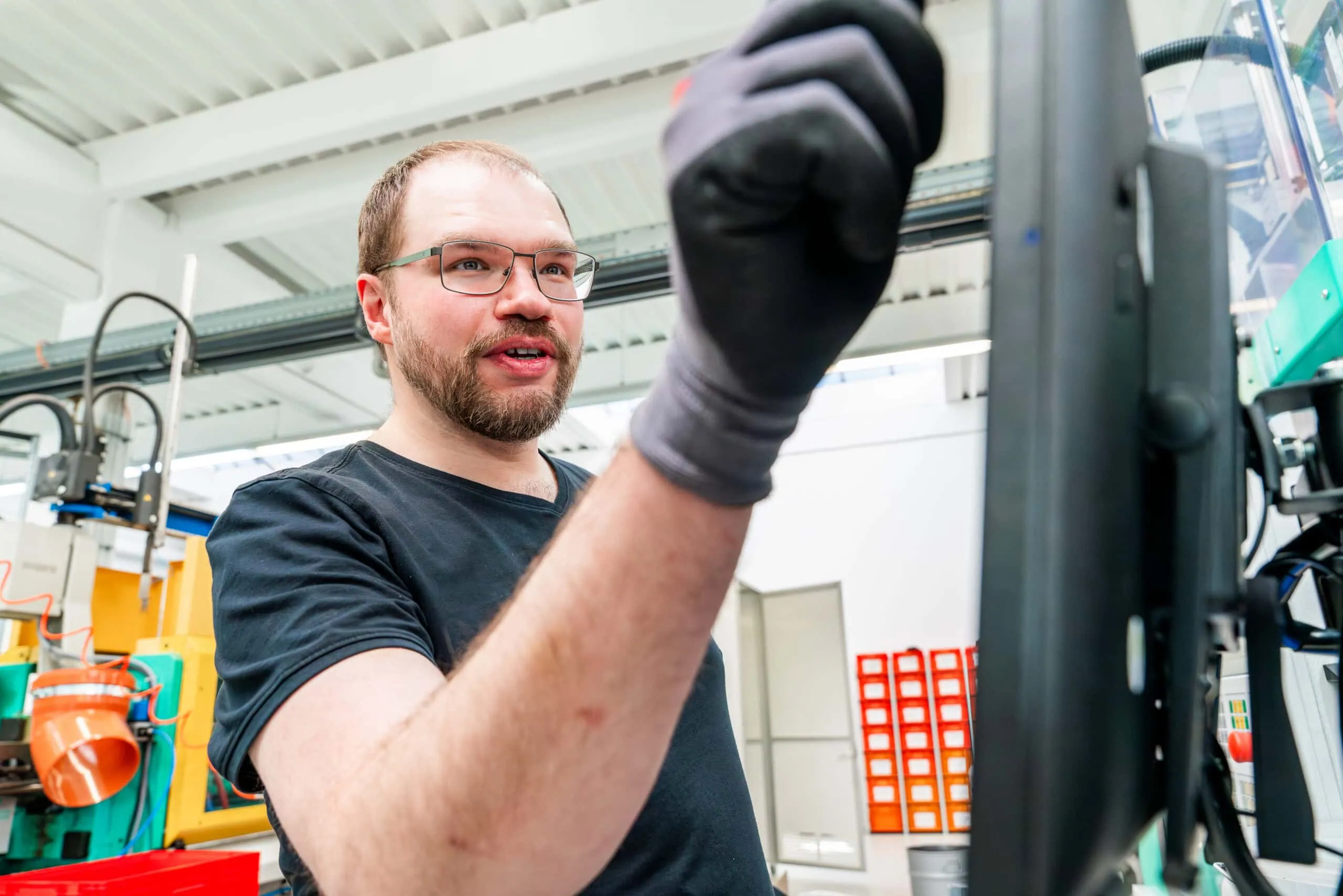 Mitarbeiter bedient eine moderne Spritzgussmaschine in der Kunststofffertigung bei priomold.